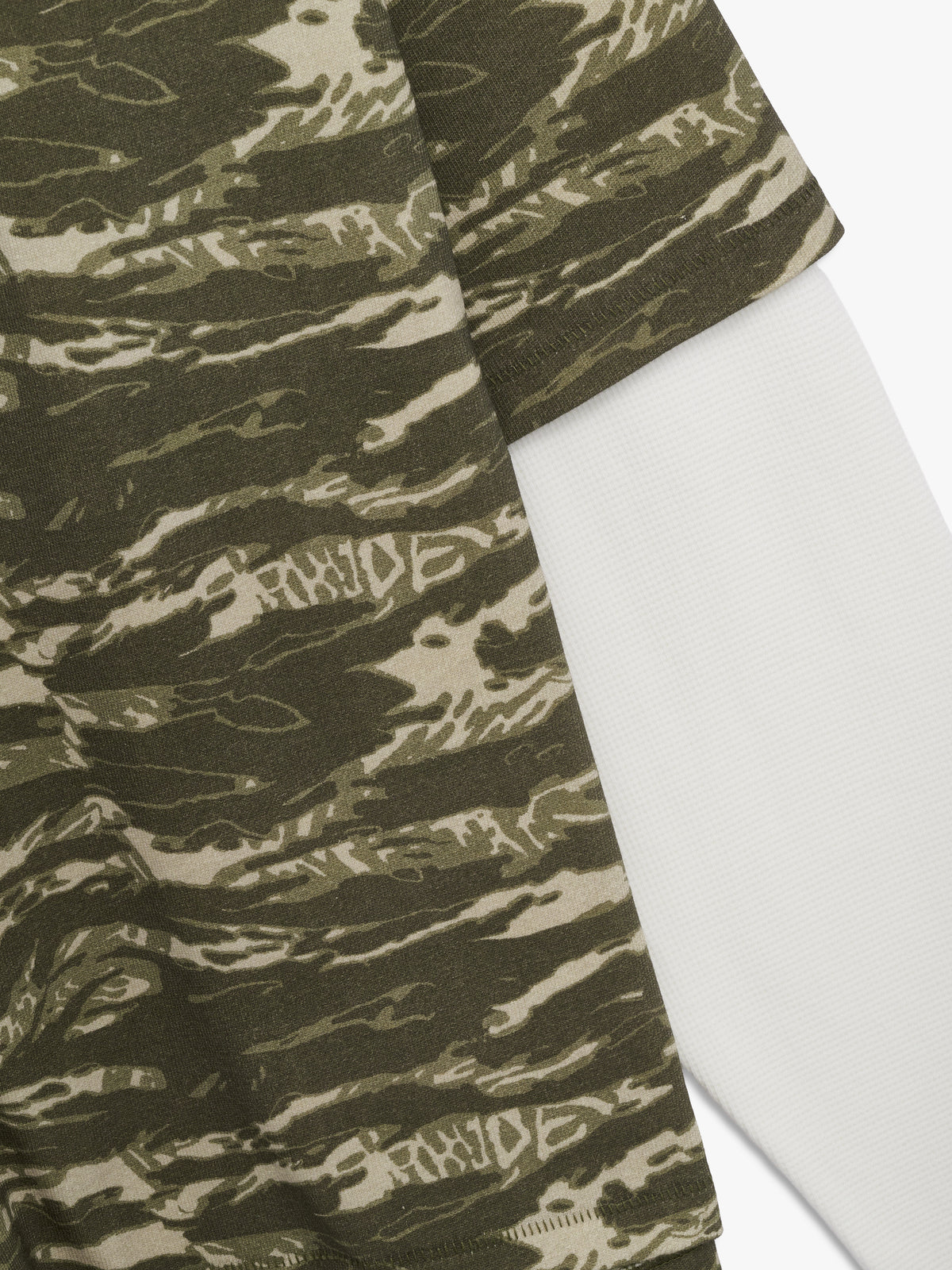 Angled close-up of the camo short sleeve layered over the white long sleeve