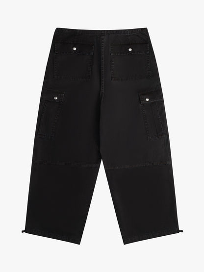 Washed black wide-leg parachute pants with snap-flap back and cargo pockets and toggled hems, back view