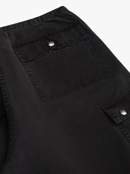Close-up of the snap-flap back pocket and side cargo pocket on the washed black parachute pants