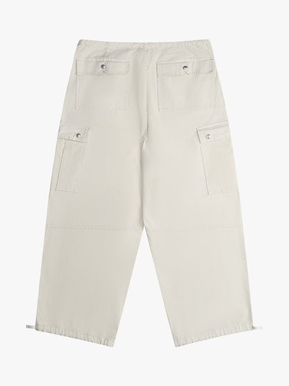 Off-white wide-leg parachute pants with snap-flap back and cargo pockets and toggled hems, back view