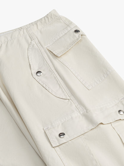 Angled close-up of the snap-flap slant and cargo pockets on the off-white parachute pants