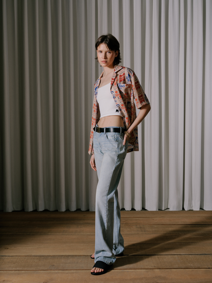 Model wearing the white rib knit cami under an open printed camp shirt with light-wash jeans, front view