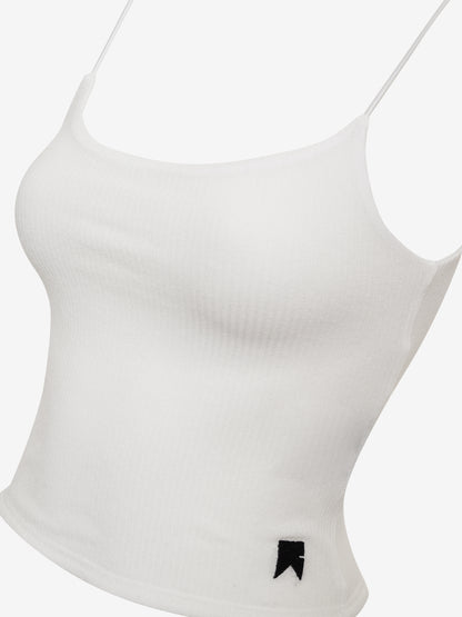 Angled close-up of the white rib knit cami top with a small black tab at the hem