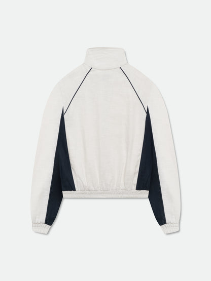 White and navy track jacket, back view with navy raglan piping, navy side panels and elastic hem