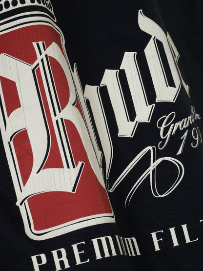 Angled close-up of the cracked white gothic Rhude on a red panel with script “Grand Cru 1991” on the vintage black tee