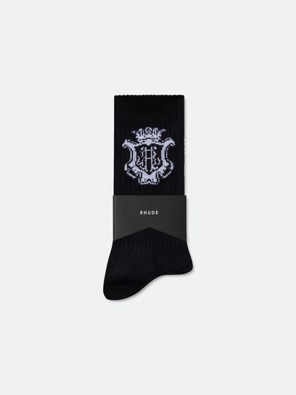 Black ribbed sock with a white crest logo, wrapped in a black RHUDE band