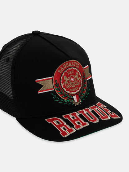 Black trucker hat with a red and tan Sausalito crest and RHUDE embroidery on the brim, three-quarter view