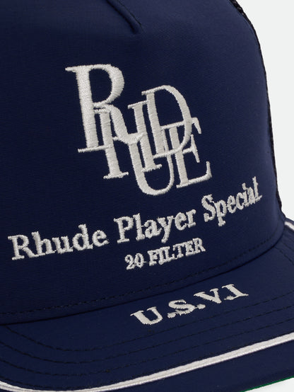 Close-up of the white embroidered RHUDE monogram, “Rhude Player Special”, “20 Filter” and “U.S.V.I” on the navy hat