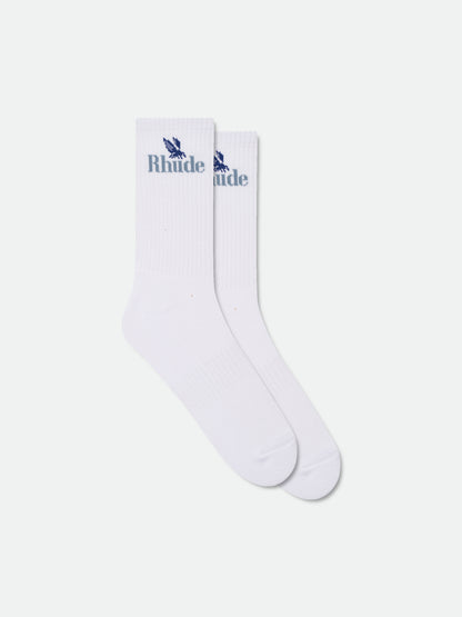 Pair of white ribbed crew socks with a blue eagle and Rhude logo at the cuff