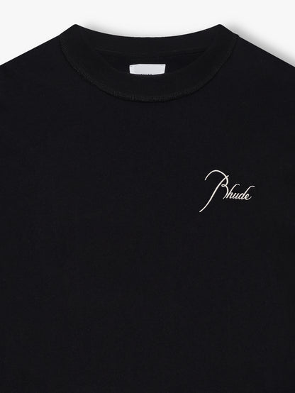 Close-up of the crew neck and cream script Rhude chest embroidery on the black sleeveless cutoff tee