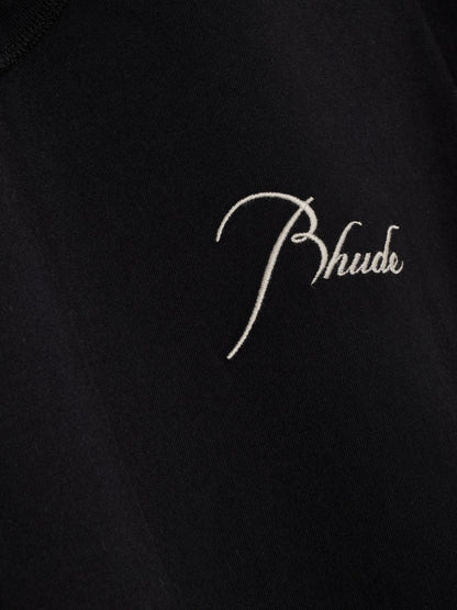 Detail of the cream script Rhude embroidery stitched onto the black sleeveless cutoff tee