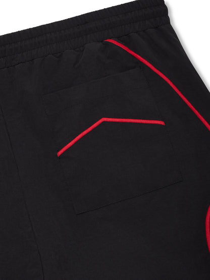 Close-up of the patch back pocket with a red chevron and red piping on the black shorts