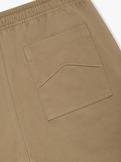 Close-up of the chevron-stitched back pocket below the elasticated waistband on the khaki twill shorts