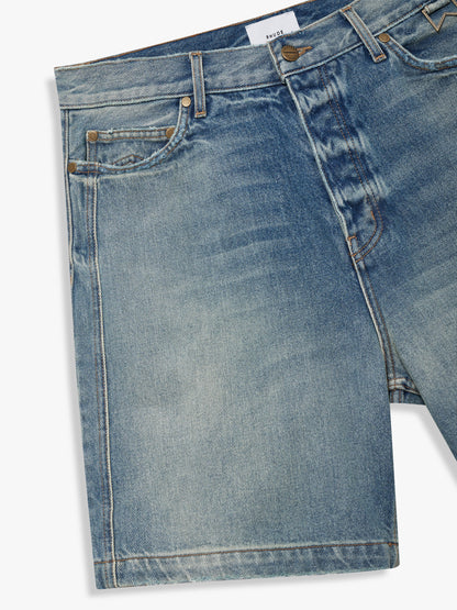 Faded indigo boxy denim shorts with whiskering and five-pocket styling, three-quarter view