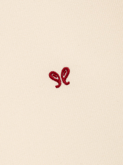 Close-up of the small red embroidered double paisley motif on the cream bowling shirt