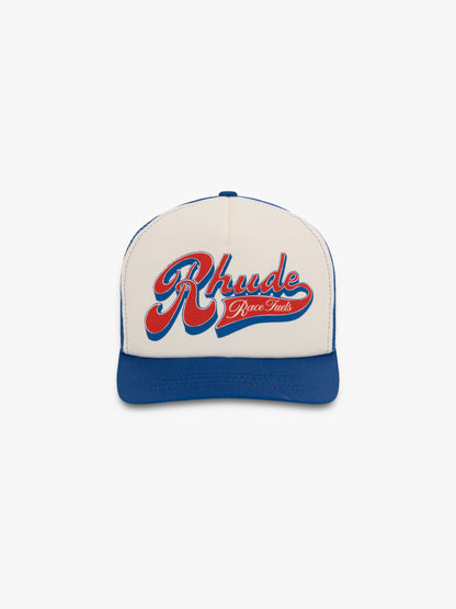 Cream and blue trucker hat with a red and blue script Rhude “Race Fuels” graphic on the front panel, front view