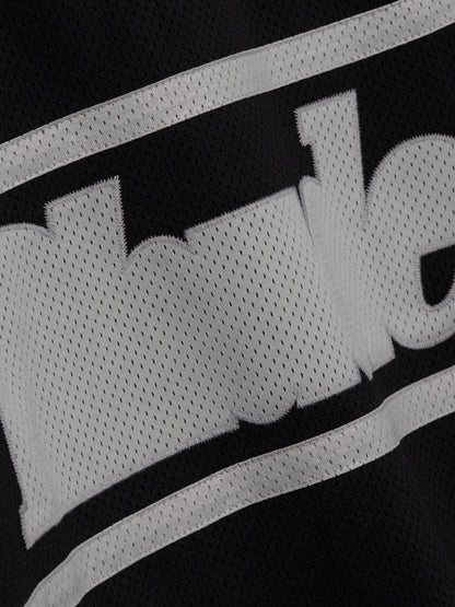 Detail of the grey Rhude logo and stripes appliquéd on the black mesh of the moto shirt