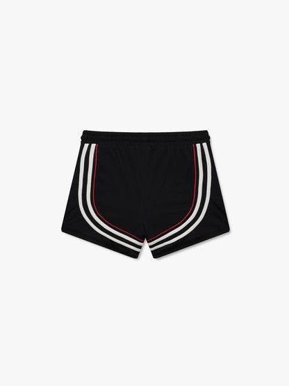 Black soccer shorts with curved white stripes and red piping, back view