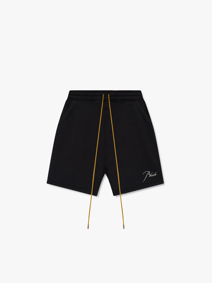 Black sweat shorts with tan drawcords, side pockets and a white script Rhude logo on the leg, front view
