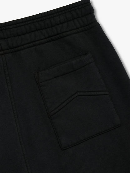 Angled close-up of the elastic waistband and rear patch pocket on the black sweat shorts