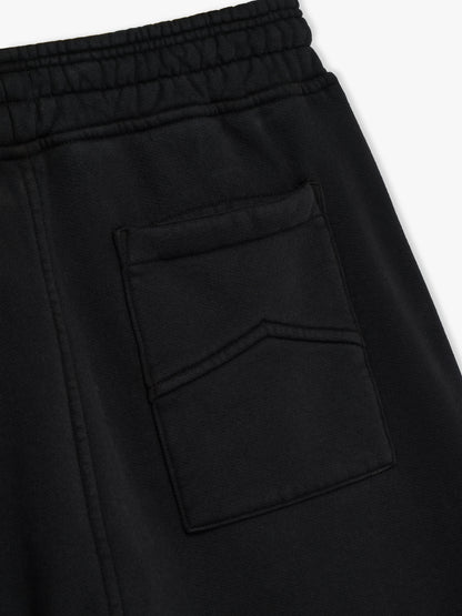 Close-up of the chevron-stitched back pocket below the elasticated waistband on the black sweatpants