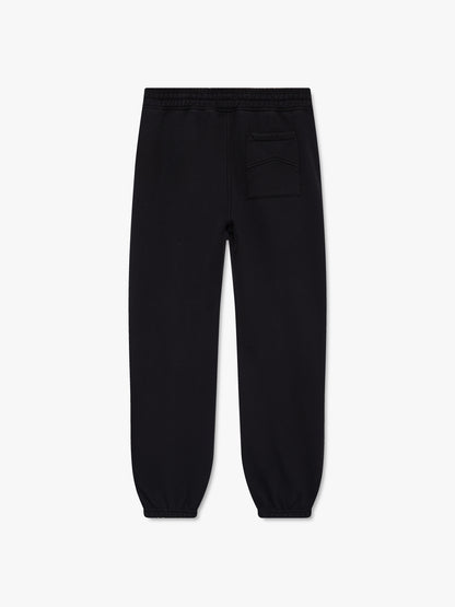 Black cuffed sweatpants with a chevron-stitched back pocket, back view