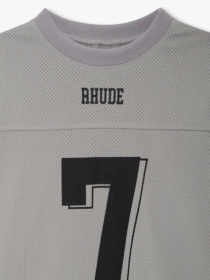 Close-up of the black RHUDE logo and number 7 below the ribbed collar of the grey mesh jersey