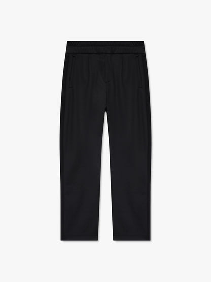 Black track pants with an elastic waist, front pintucks and slant pockets, front view