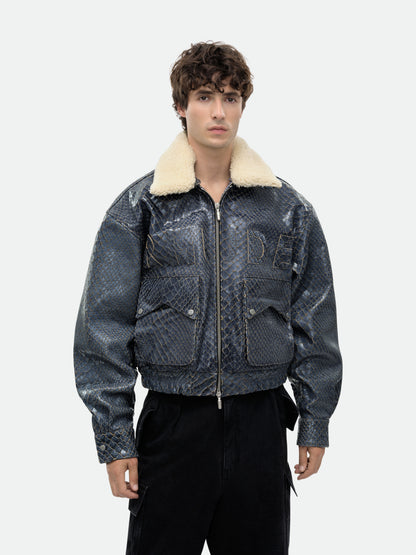 Model wearing the zipped navy crocodile-textured pilot jacket with black cargo trousers, waist-up front view