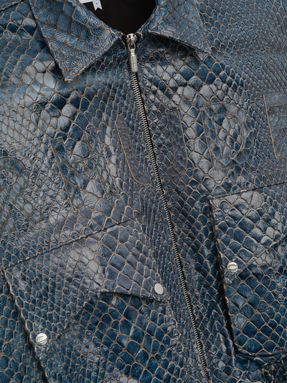 Close-up of the silver zip, pointed collar and snap flap pocket on the navy crocodile-textured jacket