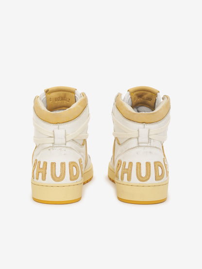 Pair of white and mustard high-top sneakers, back view with RHUDE heel lettering and mustard collar tabs